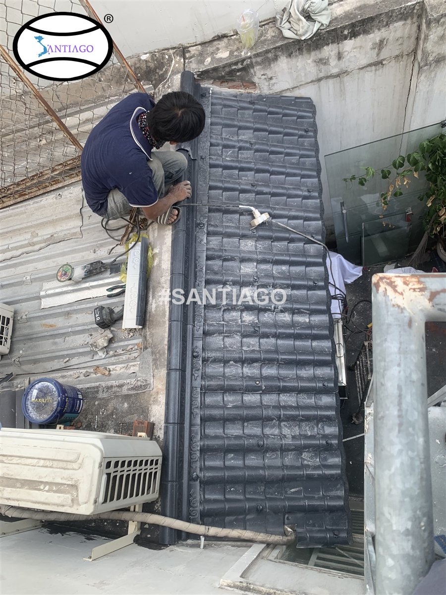Thợ đang lắp tấm ngói nhựa âm dương lên khung